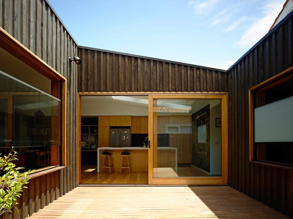 A modern home with board and batten and large windows with orange trim