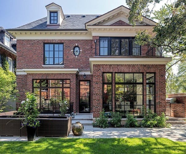 A stylish brick house with black window trim and a nice front yard.