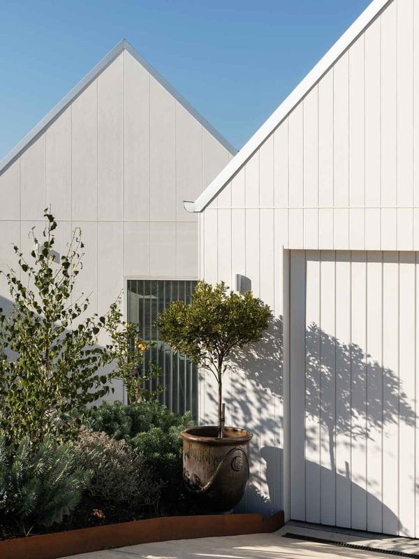 A white house with a disguised garage door that looks like the houses horizontal siding.