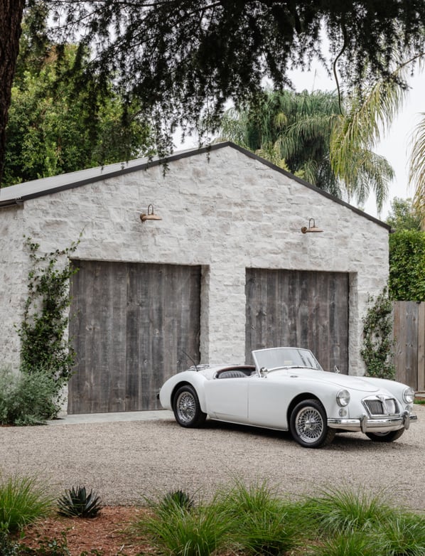 A stone two-car garage with modern wood garage door panels.