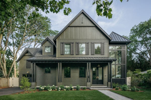A modern farmhouse home with a green board and batten exterior