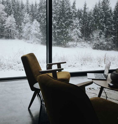 A Park City UT home office with large windows looking out to a snowy mountain scene